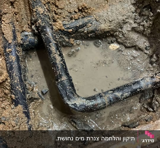 צינור מתכת מכופף בתוך בוץ רטוב
